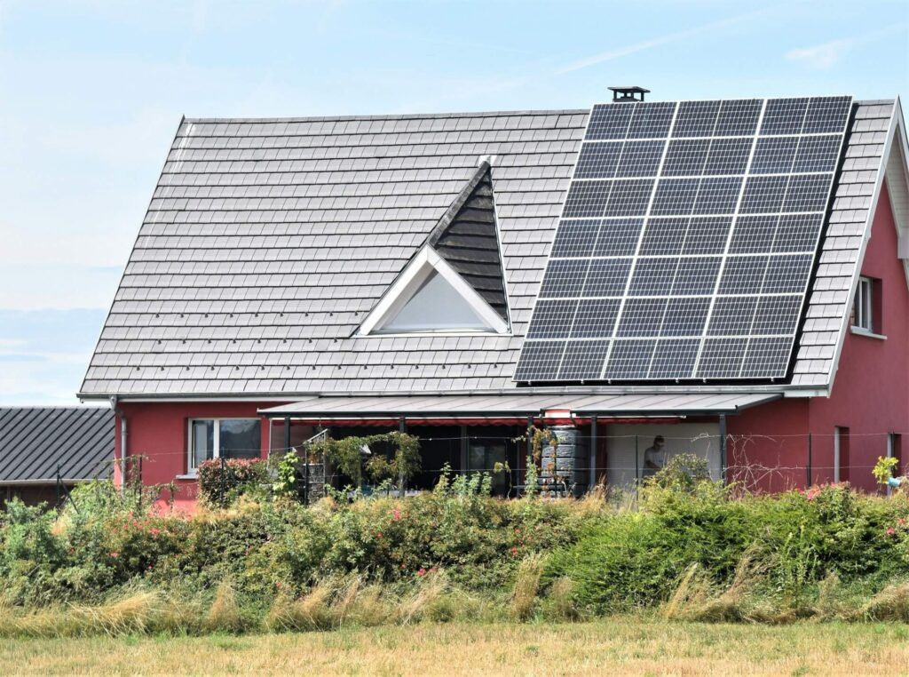 "Einfamilienhaus mit Solarpaneelen auf dem Dach, das zur Nutzung von Solarenergie geneigt ist