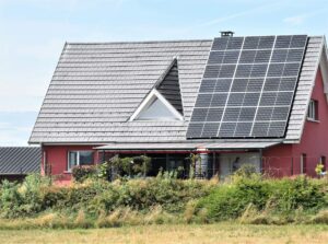 "Einfamilienhaus mit Solarpaneelen auf dem Dach, das zur Nutzung von Solarenergie geneigt ist